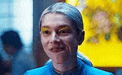 a close up of a woman wearing a blue shirt and yellow eyeshadow .