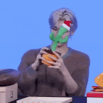 a man is holding a stuffed cactus with a santa hat on it in his hands .