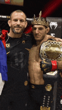 a man wearing a crown is holding a championship belt