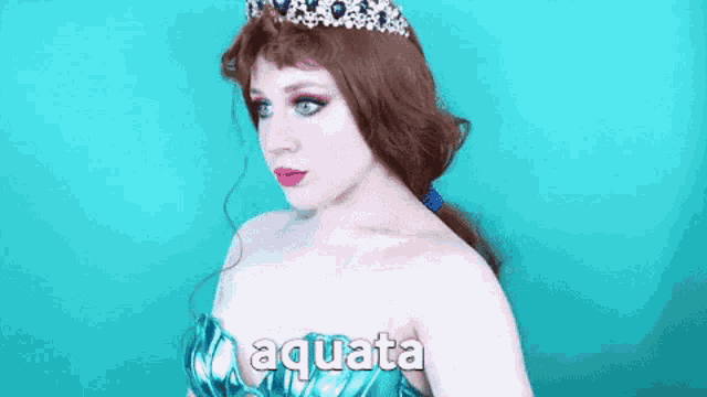 a woman in a mermaid costume is wearing a tiara and the word aquata on the bottom