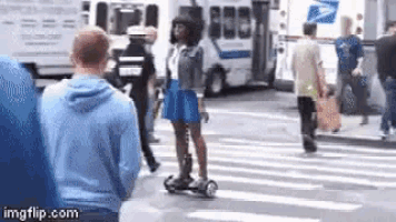 a woman in a blue skirt is riding a scooter on a street .