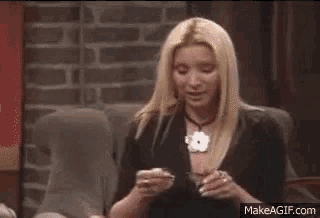 two women are sitting next to each other on a couch and one of them is holding another woman 's hair .
