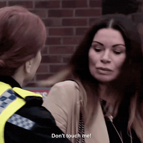 a woman is talking to a police officer who says " don 't touch me "