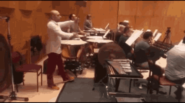 a man is playing drums in front of a group of people