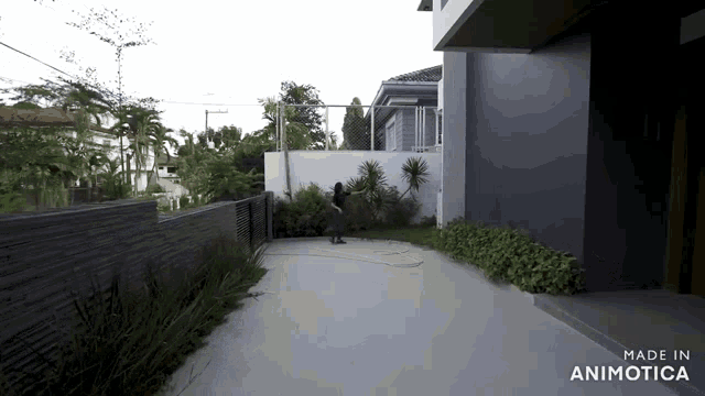 a video of a man watering plants in front of a house made in animatica