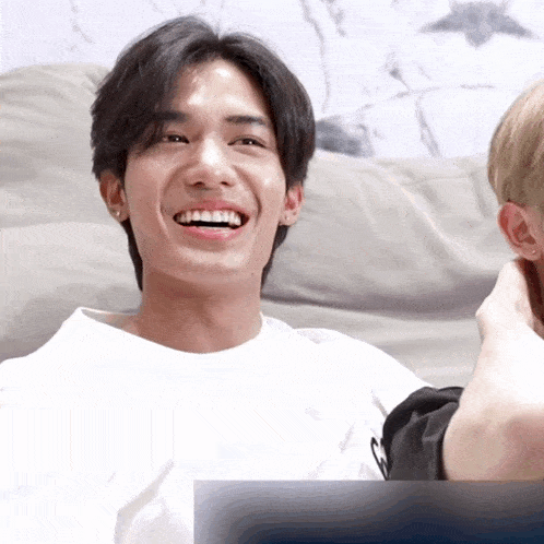 a man in a white shirt is laughing with another man