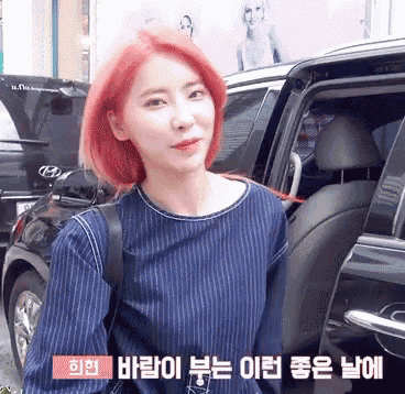 a woman with red hair is getting out of a car in a foreign language