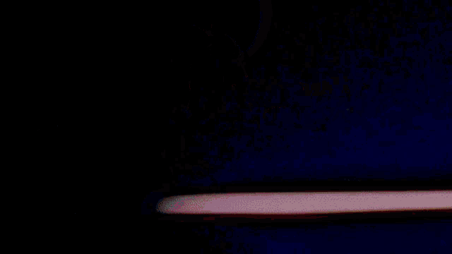 a woman in a pink jacket is driving a car with a full moon in the background