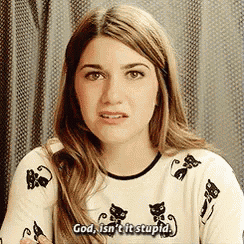 a woman wearing a sweater with cats on it is talking .