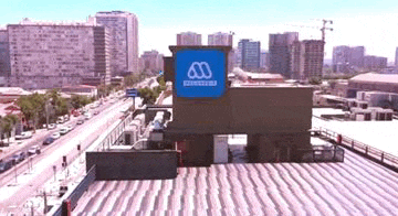 an aerial view of a building with a large blue sign on the top of it .