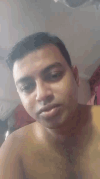 a man without a shirt is taking a selfie