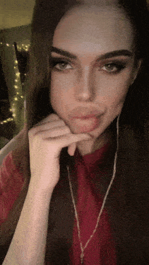 a close up of a woman 's face with a hand on her chin