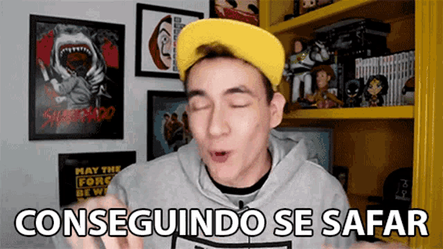 a man wearing a yellow hat and a grey hoodie says conseguindo se safari