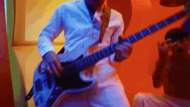a man in a white shirt plays a guitar