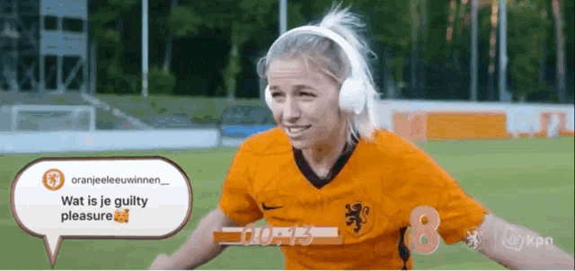 a woman wearing headphones and an orange shirt with the number 8