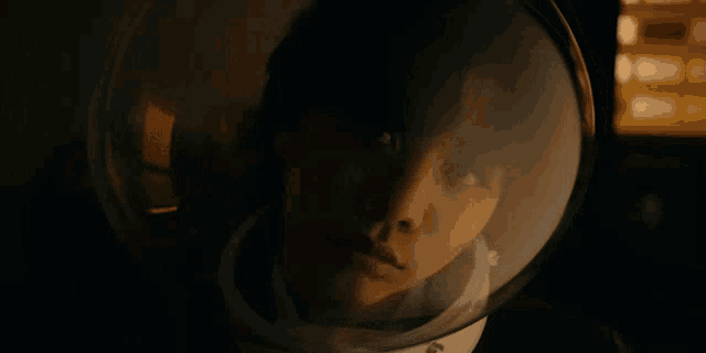 a close up of a person wearing a helmet in a dark room