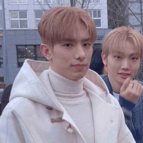 a man wearing a white turtleneck sweater and a white coat with a hood