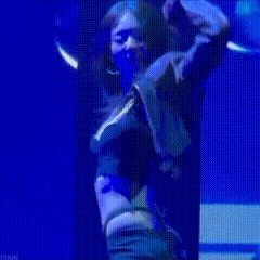 a woman with long hair is dancing on a stage in front of a blue light .