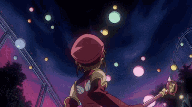 a girl in a red hat is holding a wand and looking up at a roller coaster