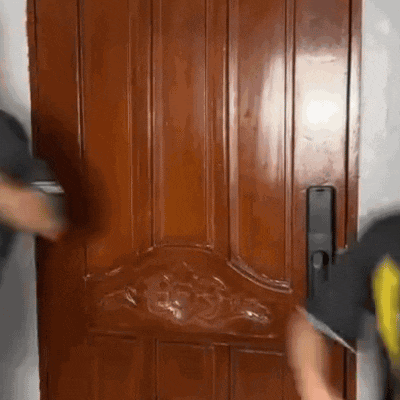 a man is standing in front of a wooden door .