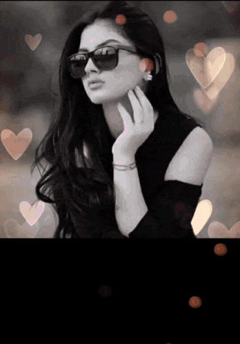 a woman wearing sunglasses is surrounded by hearts in a black and white photo