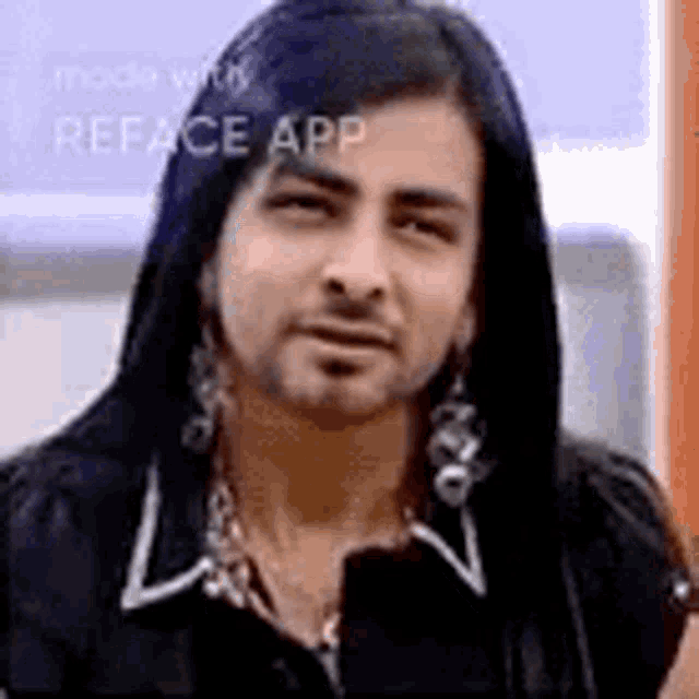 a man with long hair and a beard is wearing earrings and a hooded jacket .