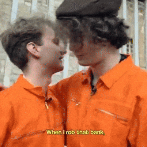 two men in orange jumpsuits are hugging each other and one of them is saying `` when i rob that bank '' .