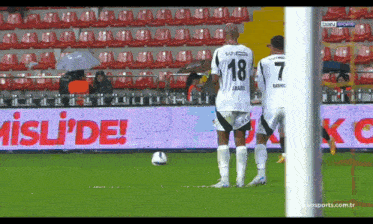 a soccer player wearing a number 18 jersey stands next to a player wearing a number 7 jersey