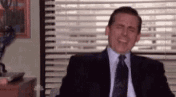 a man in a suit and tie is sitting in front of a window in an office .