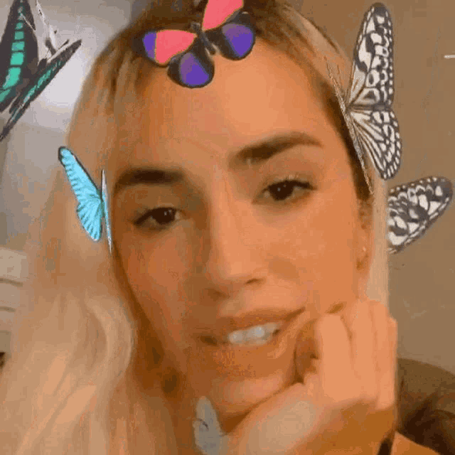 a close up of a woman with butterflies on her head .