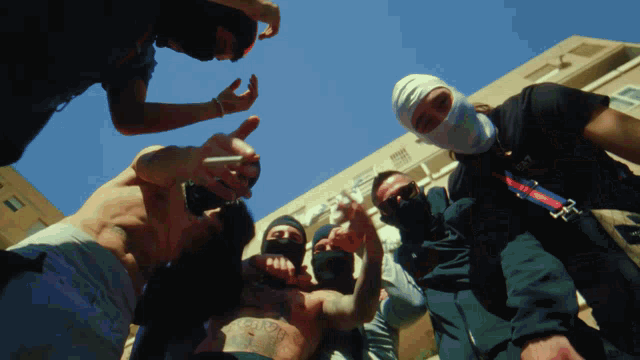 a group of men are posing for a picture and one of them is wearing a mask that says ' i love you '