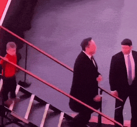 a man in a suit and tie walking down stairs
