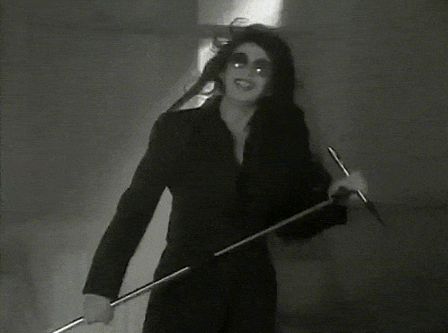 a black and white photo of a woman in a black suit