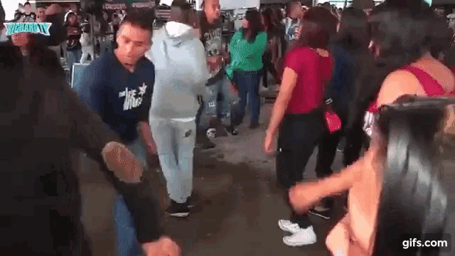 a group of people are dancing in a crowd of people .
