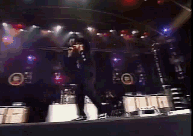 a person is walking on a stage with a microphone in their hand