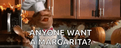 a chef is holding a spoon in his mouth and says anyone want a margarita ?