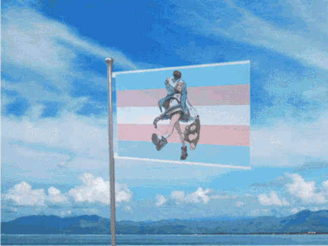 a transgender flag is flying in the wind against a blue sky