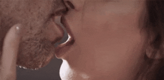 a close up of a woman kissing a man on the cheek .