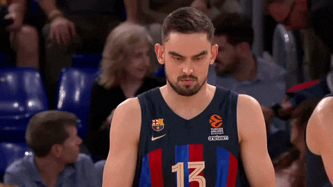 a basketball player with the number 13 on his jersey looks down