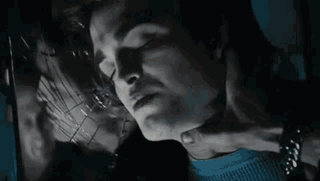 a man is sitting on a window sill in a dark room .