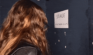 a woman looks at a sign that says stage on it