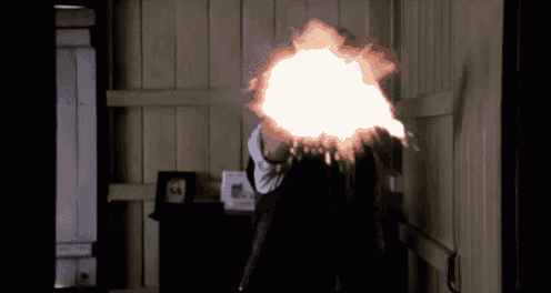 a person holding a gun with a flame coming out of it