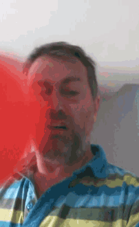 a man in a blue and yellow striped shirt is looking at the camera