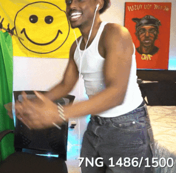 a man in a white tank top is dancing in front of a yellow smiley face flag