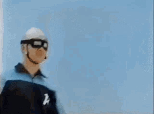 a man wearing a helmet and goggles with the letter a on his jacket .