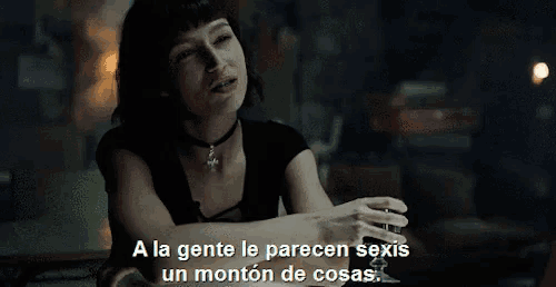 a woman sitting at a table with the words a la gente le parecen sexis un monton de cosas behind her