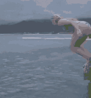 a woman in a bikini is standing on a rock in the ocean