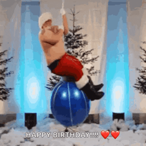 a man dressed as santa claus is balancing on a blue balloon with the words happy birthday written below him