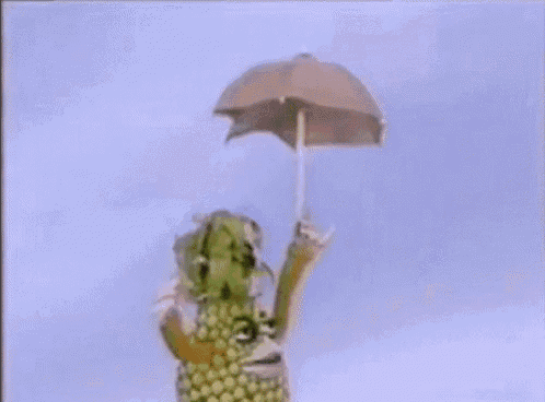 a cartoon pineapple with arms and legs is holding up its fist .