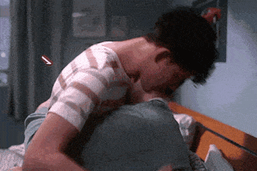 a man in a striped shirt is laying on another man 's back
